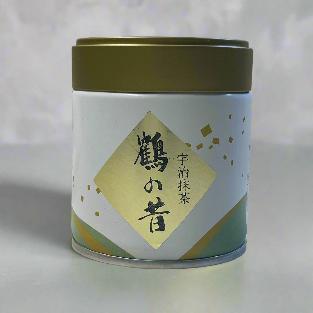 Tea canister with gold lid and green label on a white fabric background